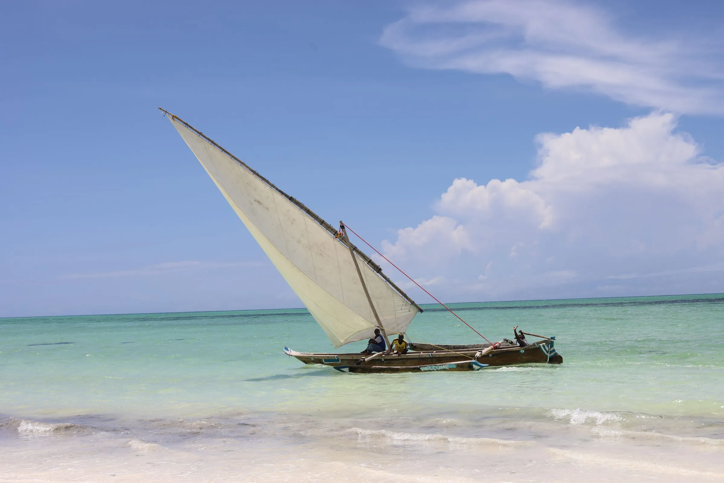 Boutre traditionnel près d'une plage aux eaux turquoise, à Zanzibar